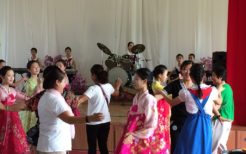 見学者と踊る北朝鮮の女子中学生