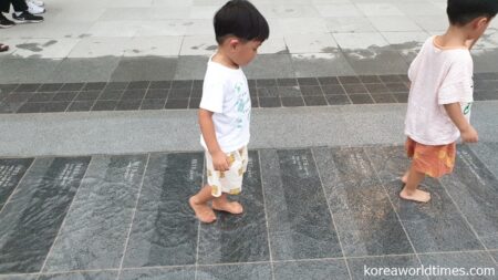 涼を求めて年表上に流れる水辺を歩く子供