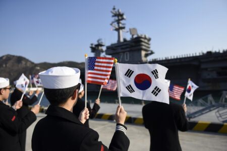 米韓の国旗を振って米空母を出迎える韓国軍水兵